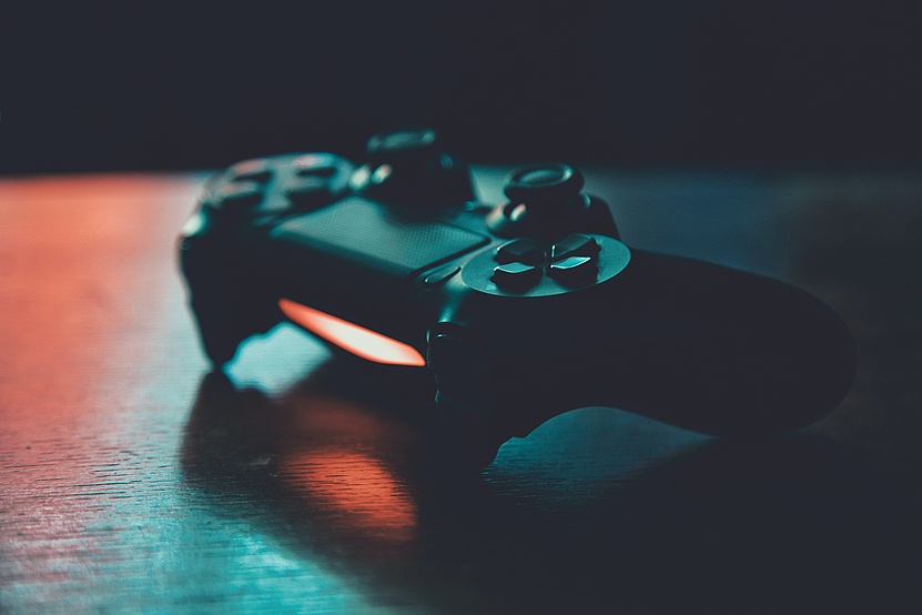 Gaming-Konsole auf einer Oberfläche - im dunklen, bläulichen Licht. 