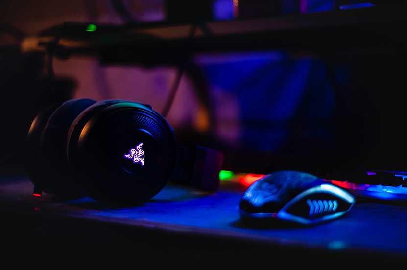 Gaming-Kopfhörer und Maus in grellen Farben.